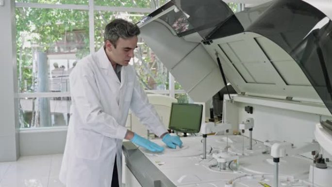 男性病理学家在测试架中组织血液样本