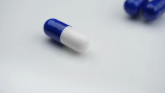 蓝色药丸落在白色表面上。