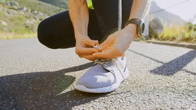 在4k乡村的道路上，高级妇女在鞋带上系鞋带