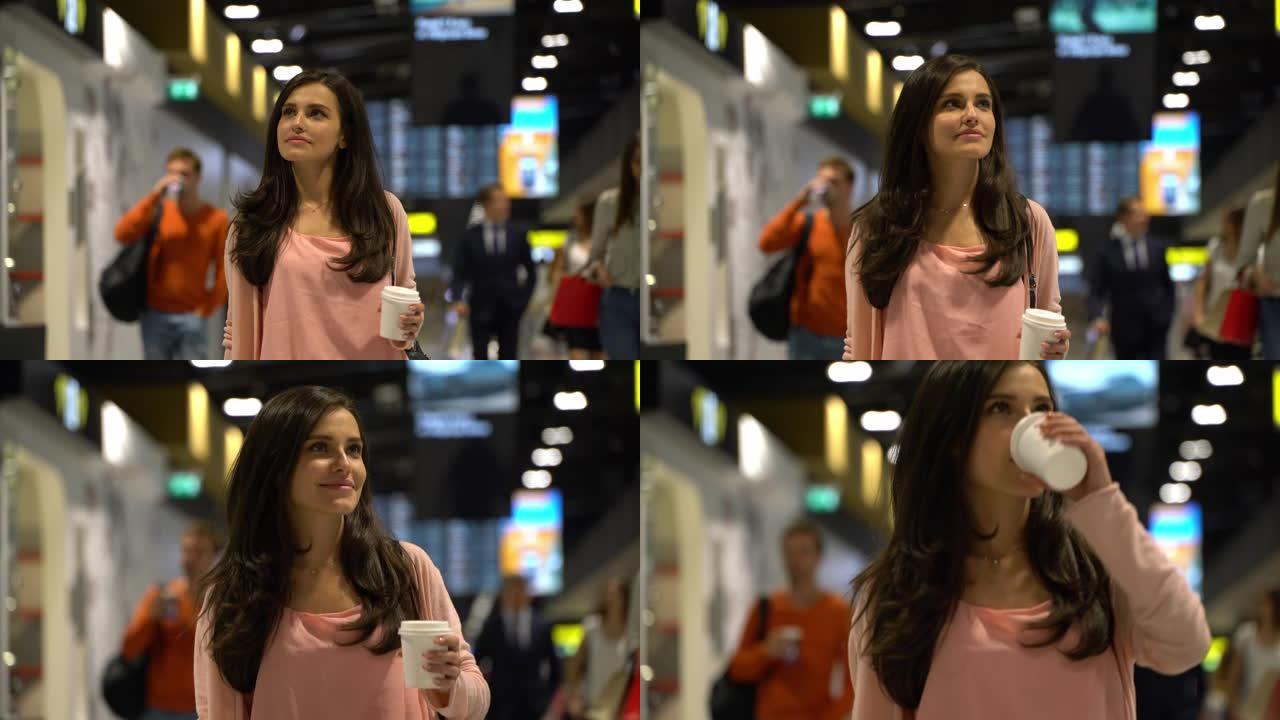 美丽的女人一边微笑着穿过机场一边享受咖啡