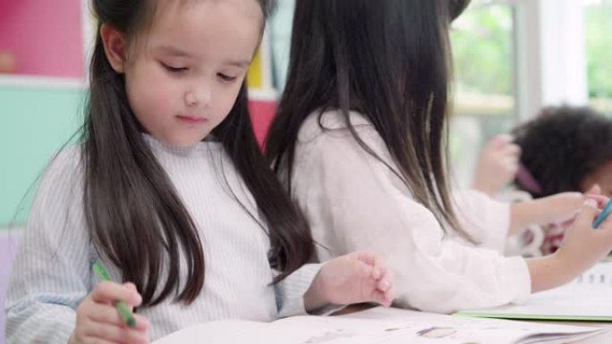 一群孩子在教室里画画，多民族的年轻男孩和女孩在小学快乐有趣的学习和在纸上画画。孩子们在学校画画的概念