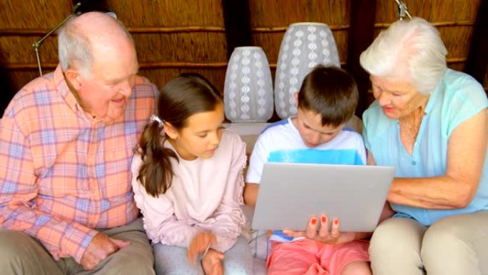 在舒适的家庭4k中使用笔记本电脑的多代高加索家庭的前视图