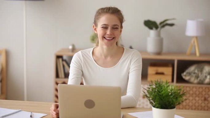 微笑的女孩与笔记本电脑合影，在家工作