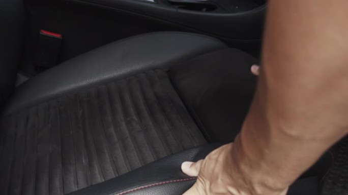 亚洲男子使用超细纤维擦拭清洁汽车座椅和汽车控制台