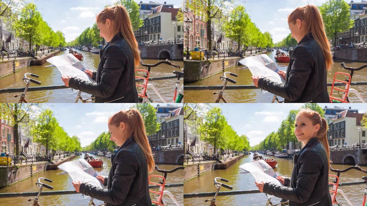 女子手持阿姆斯特丹地图，站在运河上方的桥上，背景为游船