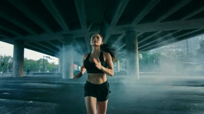 一个美丽自信的健身女孩穿着黑色运动上衣和短裤在烟雾缭绕的街道上慢跑的肖像照片。她在城市环境中奔跑，背