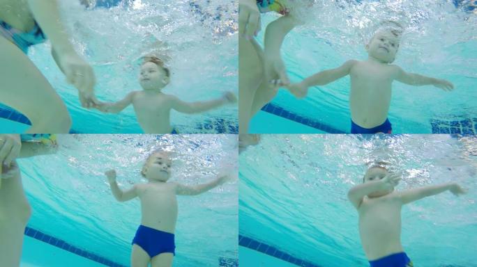 一个妈妈和一个儿子在游泳池里水下训练，特写。