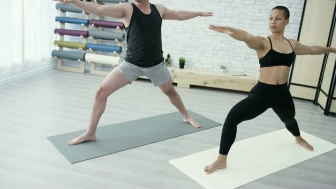 少数民族成年夫妇在健身室一起做瑜伽