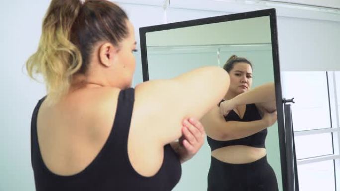 胖乎乎的女人概念照镜子赘肉