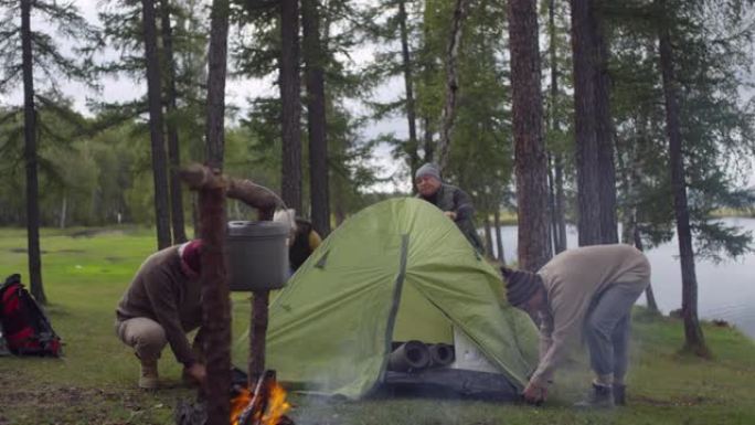 高级露营者在松树林中搭建帐篷