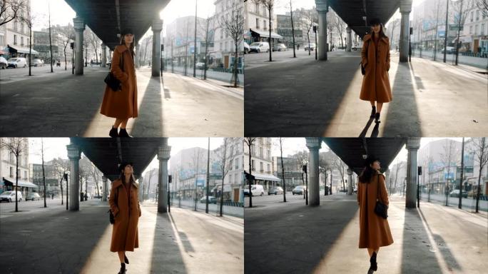 美丽优雅的旅游女人沿着巴黎街走在地铁天桥下，回头看相机微笑慢动作
