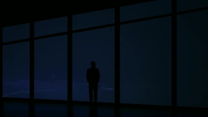 在雷电背景下的夜晚雷雨中，该男子站在窗户附近