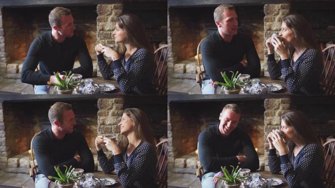 夫妇坐在餐桌旁，在传统的英国度假酒店喝茶-慢动作拍摄