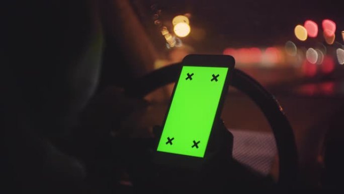 晚上在汽车上使用智能手机的妇女，绿屏