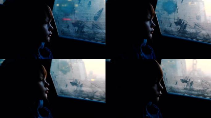 在黄昏黑暗的夜晚，4-6岁的小思想高加索男孩从雾蒙蒙的车窗外望去。