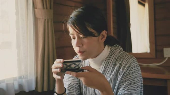 年轻的亚洲妇女饮热茶仪式