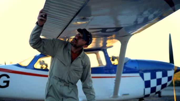 男飞行员检查飞机机翼，特写。