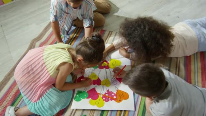 幼儿在幼儿园手工海报上画画