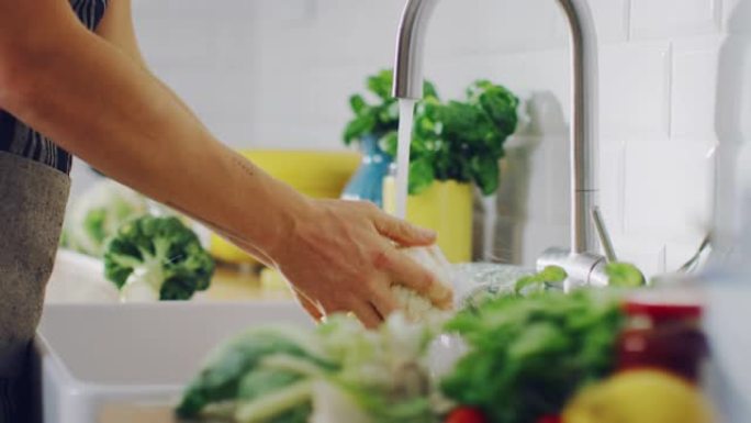 慢动作特写一个人用自来水洗花椰菜的镜头。正宗的时尚厨房配健康蔬菜。有机农业手工清洗的天然清洁产品。