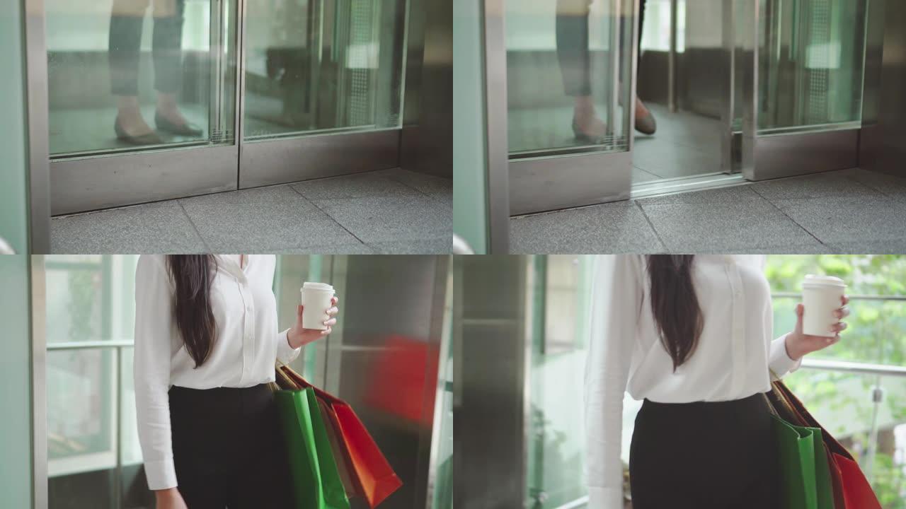 年轻女子拿着购物袋并使用电梯