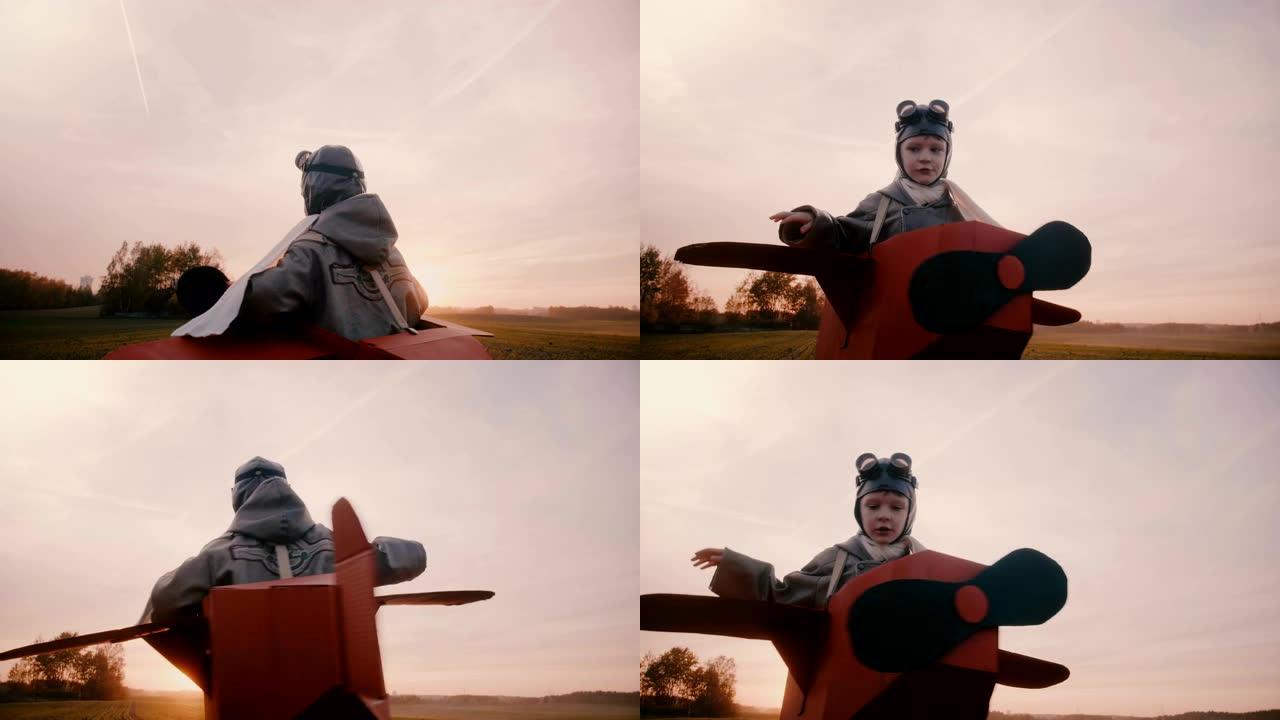 快乐的小男孩穿着有趣的纸板飞机服装在日落秋野外旋转，玩航空飞行员慢动作。