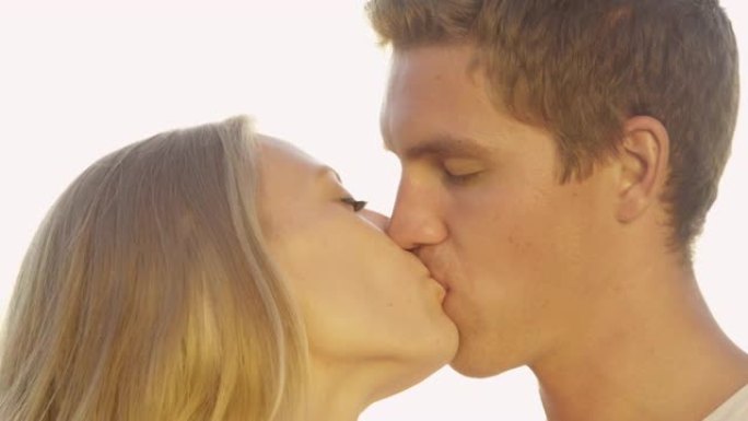 慢动作: 快乐的年轻新婚夫妇在亲热接吻前摩擦鼻子。