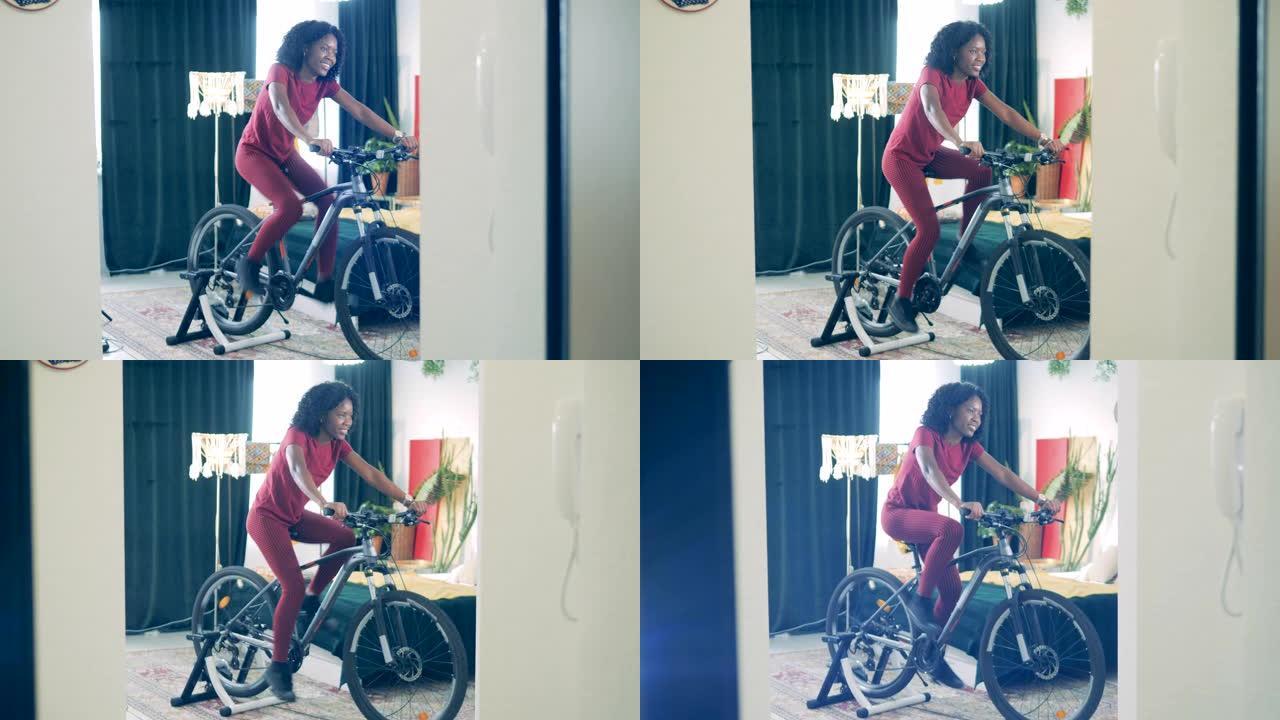 年轻的非洲女士正在使用自行车机器在家训练