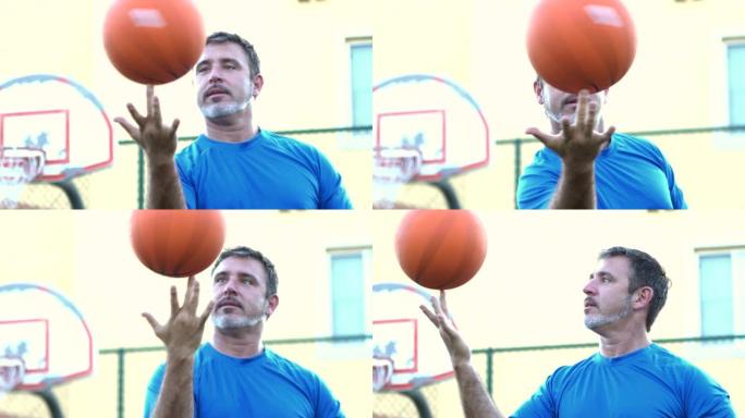 成熟的西班牙裔男子在指尖上平衡篮球