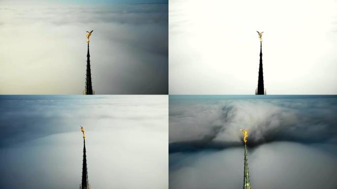 无人机在圣米歇尔要塞山顶上的金色圣迈克尔雕像周围飞行，在云层上方的阳光下发光