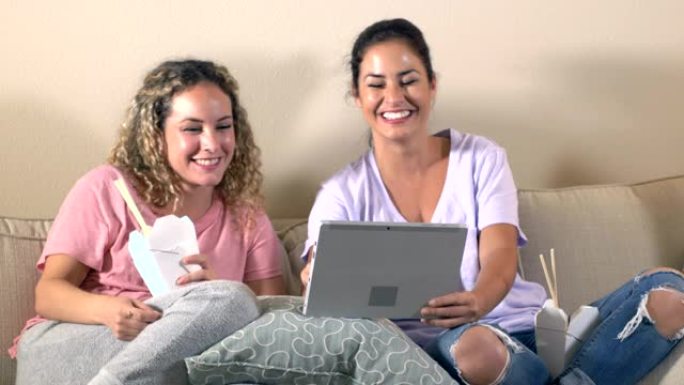 西班牙裔姐妹使用平板电脑，吃中国外卖