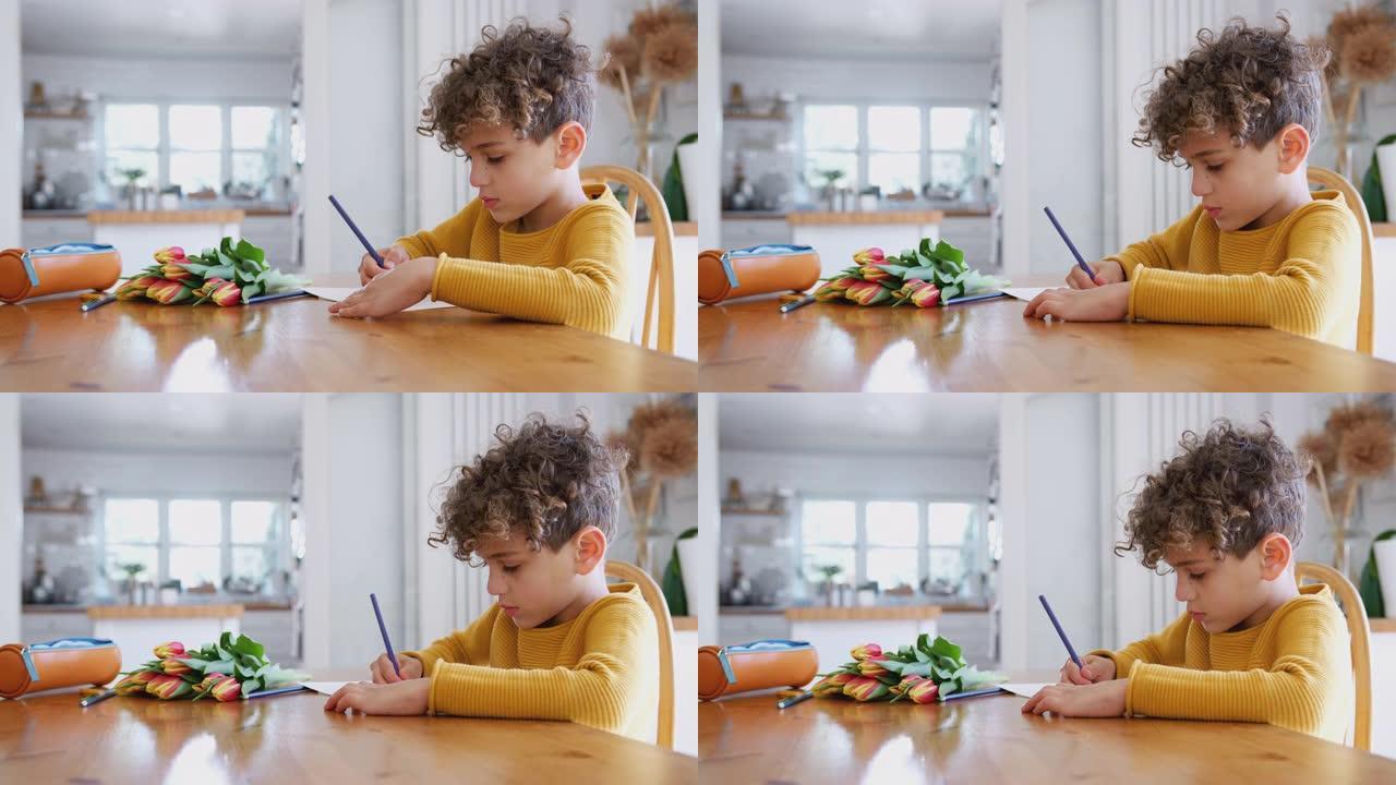 小男孩在家，在母亲节卡片上写着一束鲜花