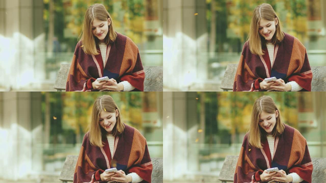 女士在秋季公园用智能手机发短信