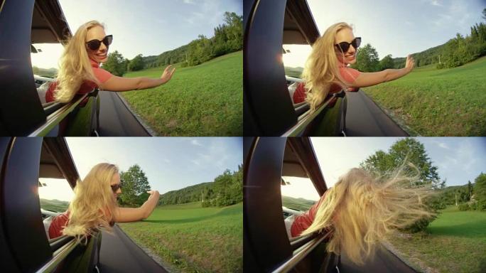 慢动作: 年轻女孩开车穿过乡村时伸出车窗。