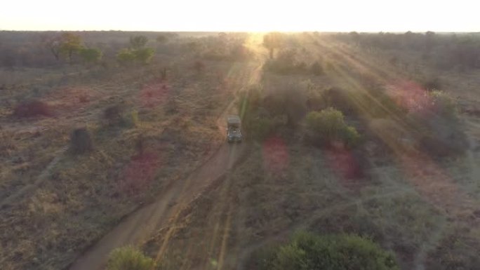 津巴布韦万基国家公园，一辆4x4野生动物园车辆在日落时玩游戏的4k空中缩小视图