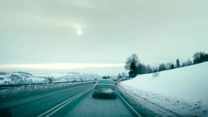 在路上。驾驶员的POV，看着积雪覆盖的世界