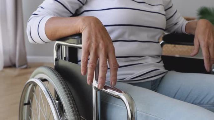退休老妇独自坐在轮椅上在家。