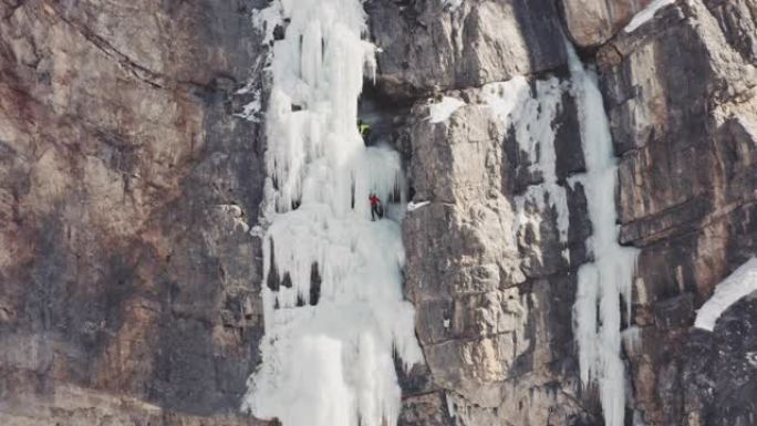 在瀑布上爬冰山顶上攀登的人勇敢拼搏精神奋