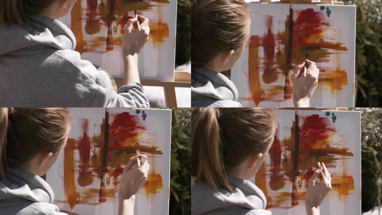 女艺术家在户外用油画绘画