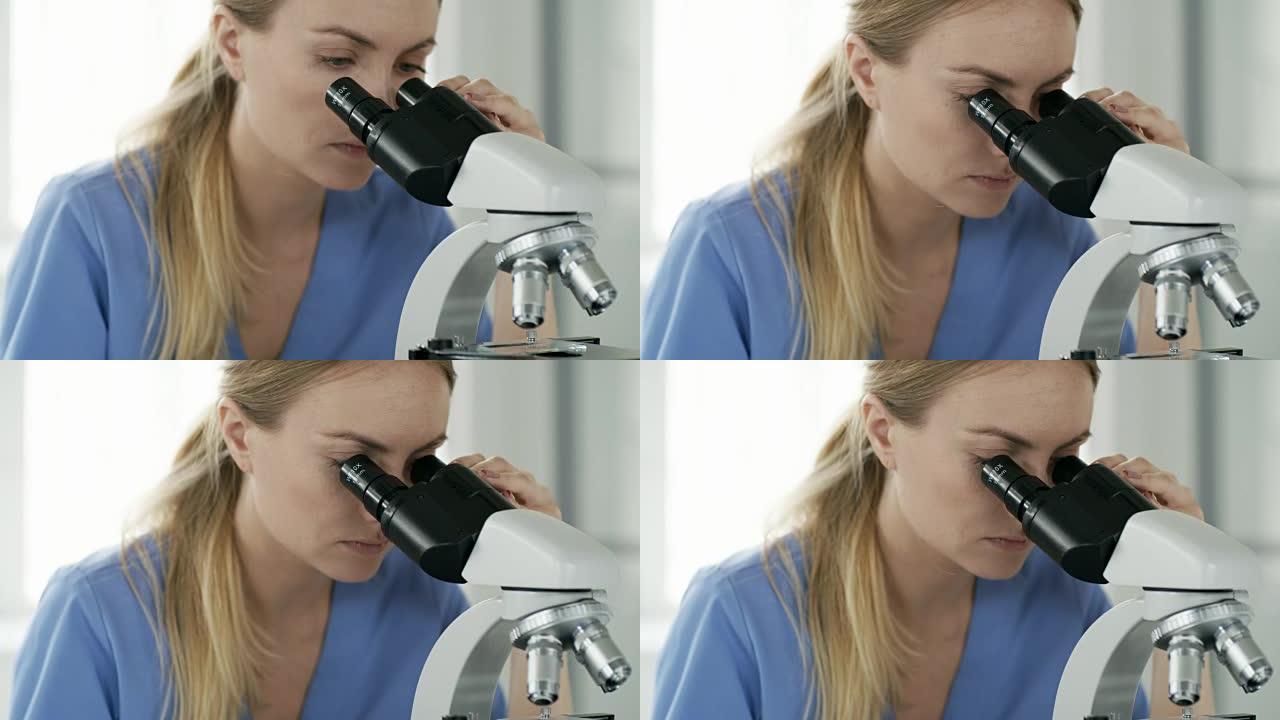 女性生物化学家在工作中使用显微镜