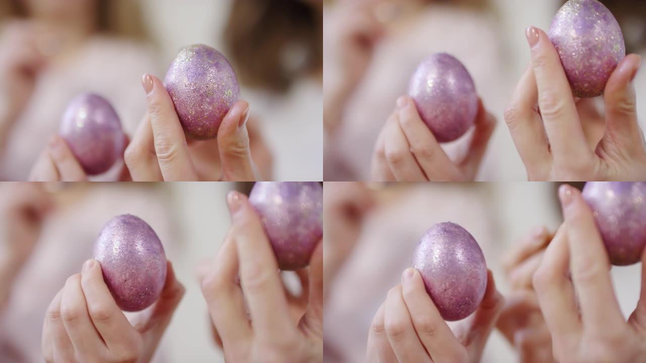 手握着用闪光颜料装饰的复活节彩蛋
