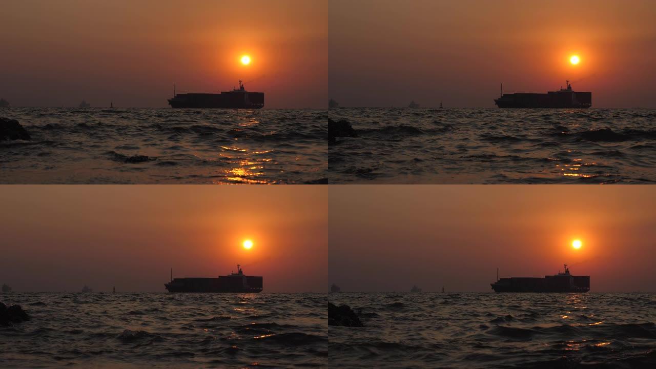 日落时分在海上航行的货运集装箱船