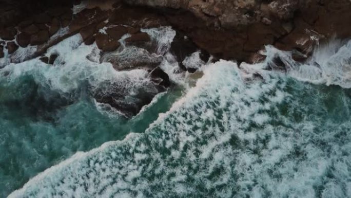 鸟瞰图和海浪撞击岩石的放大图