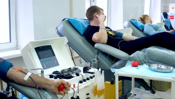 志愿者在现代化的中心献血，医疗机器在工作。