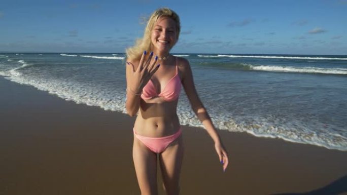 南非，一个美丽的年轻女子调情地呼唤某人进入海浪寻找乐趣的4k视图