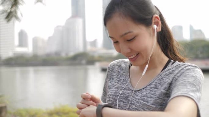 亚洲年轻女子在智能手表上监控她的跑步表现