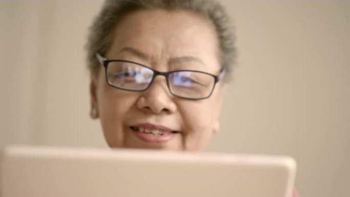 祖母在数字平板电脑上阅读一些东西
