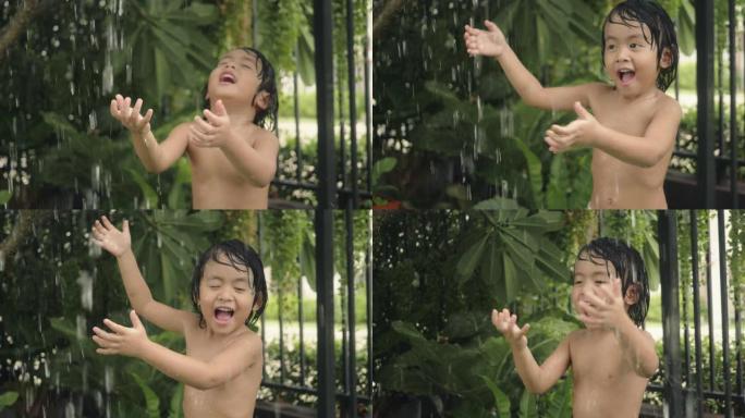 快乐的小男孩玩洒水器。