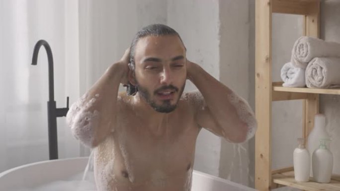 性感的男人在浴缸中头部出水和摆姿势