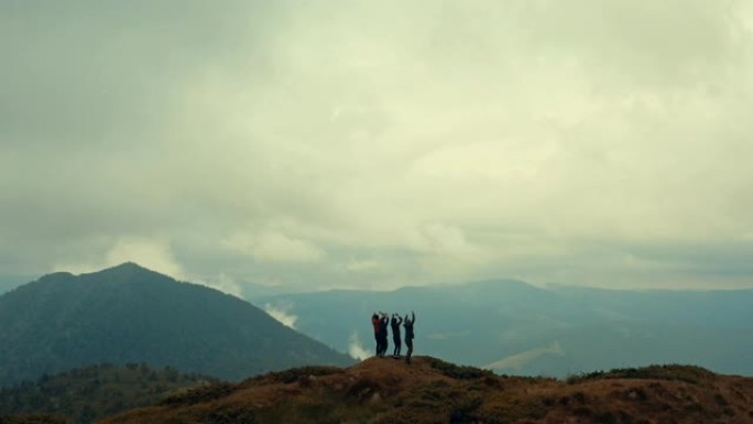 四个朋友在美丽的山顶上跳舞