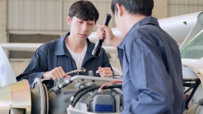 领导力亚洲青少年男孩发展工程师在机库飞机上教授工程维护。技术，科学，STEM，创新，领导力，赋权，专